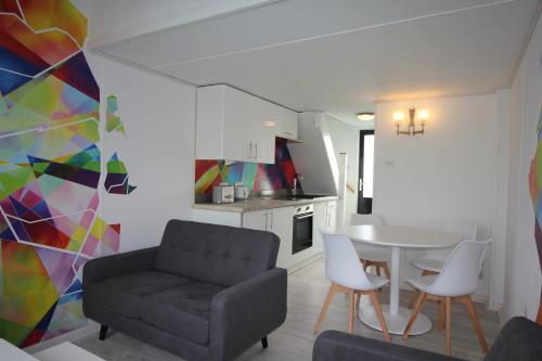 a living room with a couch and a table and chairs at Fabulous Waterfront Apartment in Brighton Marina in Brighton & Hove