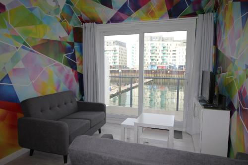 a living room with a couch and a window at Fabulous Waterfront Apartment in Brighton Marina in Brighton & Hove