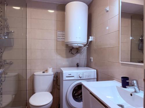 ein Badezimmer mit Toilette, Waschbecken und Waschmaschine in der Unterkunft Garden City in Playa Fañabe