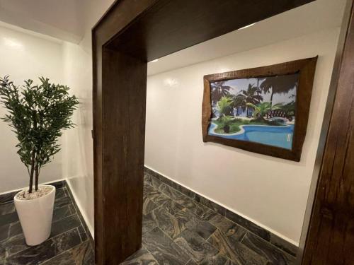 a hallway with a potted plant and a painting on the wall at Presken Residence in Ikeja