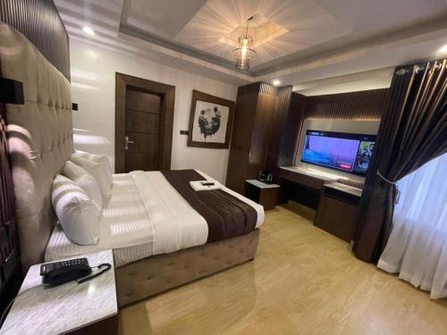 a hotel room with a bed and a television at Presken Residence in Ikeja