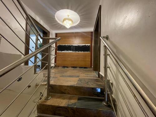 a staircase in a house with a chandelier at Presken Residence in Ikeja
