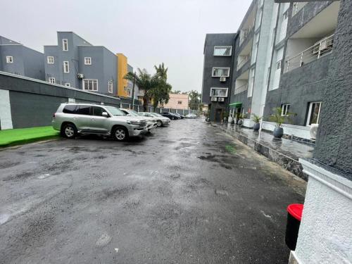 a parking lot with cars parked next to buildings at Presken Residence in Ikeja
