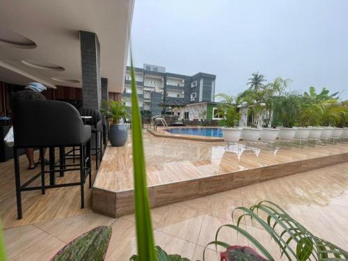 a person sitting at a table on a balcony with a pool at Presken Residence in Ikeja