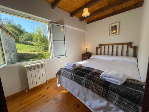 a bedroom with a bed and a large window at casita en Fresinidiello para 4 personas 