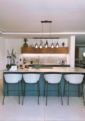 una cucina con una grande isola con sgabelli da bar di Villa Anjo a Zonza