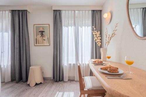 ジュネーヴにあるResidence CITYZEN - Genèveの食べ物が置かれたテーブルのあるダイニングルーム