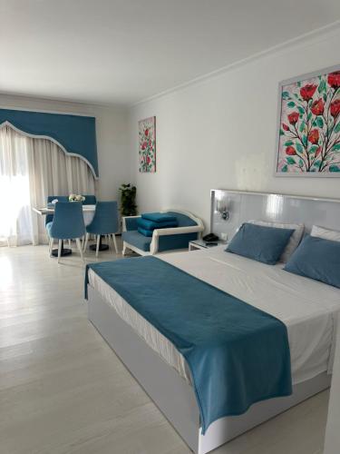 a bedroom with a large bed with blue sheets at Domina Coral Bay Elisir in Sharm El Sheikh