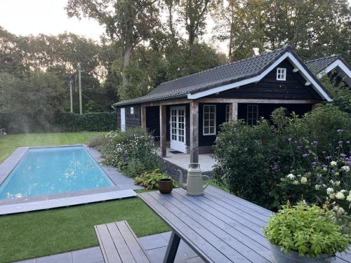 a backyard with a small house and a swimming pool at Chalet Santpoort-Zuid in Santpoort-Zuid