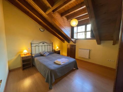 an attic bedroom with a bed and a window at Casa Carmen in Infiesto