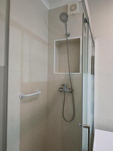 une douche avec pommeau de douche dans une salle de bain dans l'établissement Casa da Familia Pereira, à Corroios