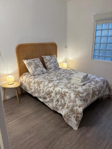 a bedroom with a large bed with a wooden headboard at Villa Fleur de Tiaré in Saint-Paul