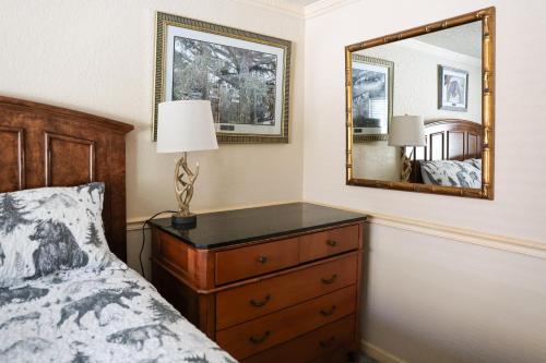 a bedroom with a bed and a dresser with a mirror at Yellowstone Gateway Inn in Gardiner