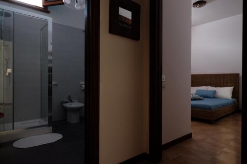 a bathroom with a bed and a shower and a toilet at Pompei Rooms and Apartment in Pompei