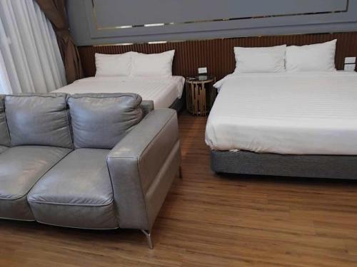 a living room with two beds and a couch at Lemon Apartment Quy Nhơn in Quy Nhon