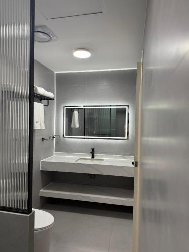 a bathroom with a white sink and a mirror at Ranveli Dhigurah in Dhigurah