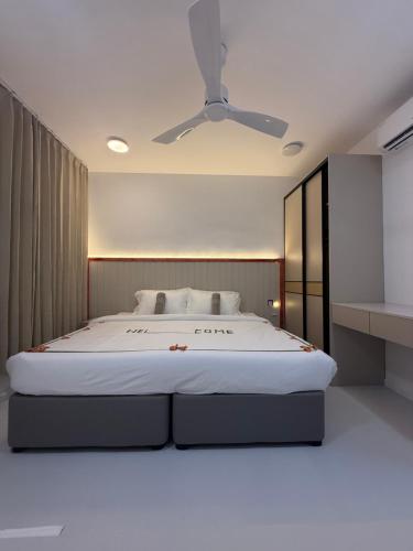a bedroom with a large bed with a ceiling fan at Ranveli Dhigurah in Dhigurah