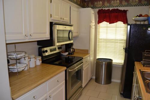 una cucina con armadi bianchi e un forno a piano cottura nero di 169 Cordero Lane a Hot Springs Village