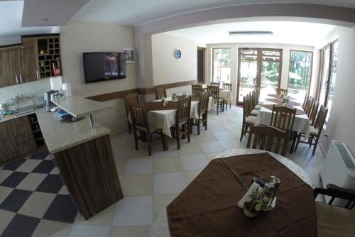 a restaurant with a dining room with tables and chairs at Ивелия Къща за гости in Dospat