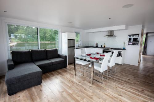 a living room with a couch and a table and chairs at Yacht Club de Trois-Rivières 2 - Maison flottante in Trois-Rivières