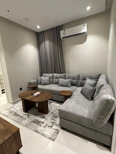 ein Wohnzimmer mit Sofa und Tisch in der Unterkunft Two Bedroom Luxury Apartment in Dschidda