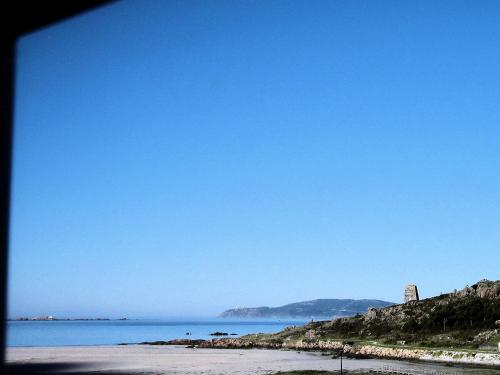 a beach with a clear blue sky and the ocean at Apartamentos Playa Monte Pindo - Lobeira do Mar in O Pindo