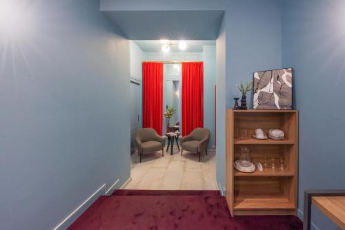 a hallway with red curtains and a table and chairs at HB Freeze Inn in Tbilisi City