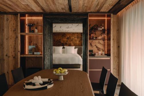 a bedroom with a bed and a table and chairs at Rosewood Courchevel Le Jardin Alpin in Courchevel