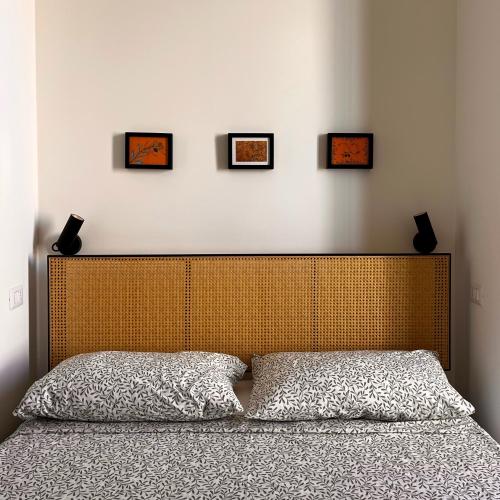 a bedroom with a bed with four pictures on the wall at Foglie d'ulivo in Mola di Bari