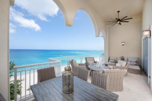 balkon ze stołem i krzesłami i widokiem na ocean w obiekcie Beachcomber 36 w mieście George Town