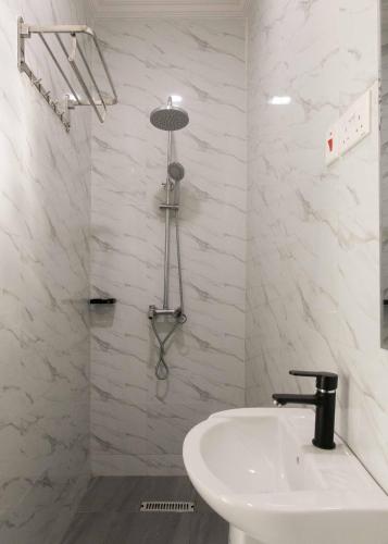 a white bathroom with a sink and a shower at The horizon view lodge in Chipata