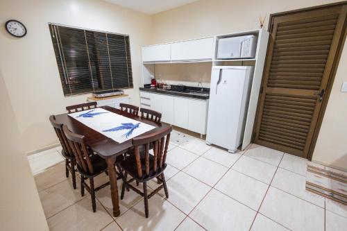 a kitchen with a table and chairs and a refrigerator at Green Garden Foz - Casas e Lofts em um Bosque in Foz do Iguaçu