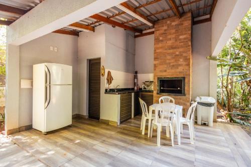 Una cocina con refrigerador y una mesa y sillas. en Green Garden Foz - Casas e Lofts em um Bosque, en Foz do Iguaçu
