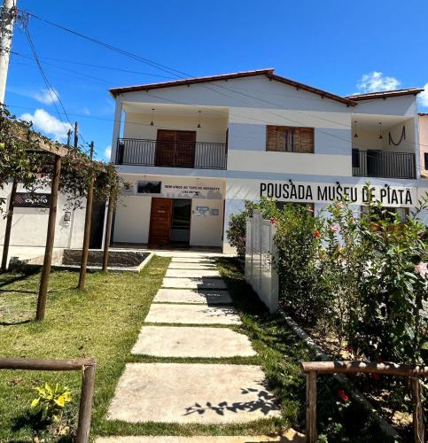 a house with a sign that reads pussula music piano at Pousada Museu de Piatã in Piatã