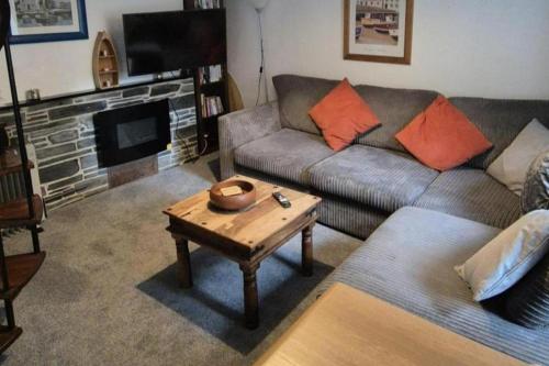 a living room with a couch and a coffee table at Cottage in village of Mevagissey Cornwall Sleeps 4 in Mevagissey