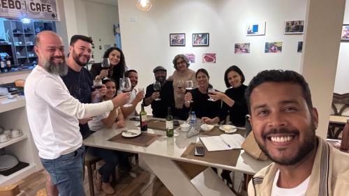 a group of people sitting around a table drinking wine at Pousada Museu de Piatã in Piatã