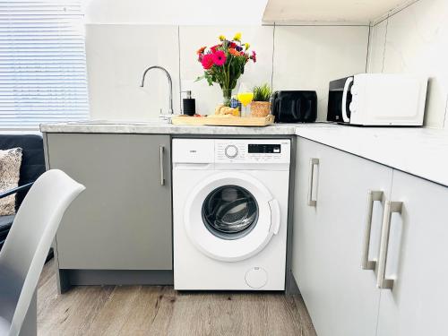 a kitchen with a washing machine under a counter at Perfectly Located City Centre Apartments in Reading
