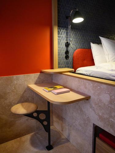 a room with a bed and a table with a book at Hotel Frihavnen in Copenhagen