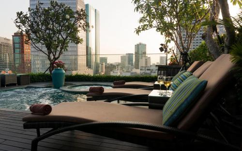 a group of chairs sitting next to a swimming pool at Silverland Jolie Hotel in Ho Chi Minh City