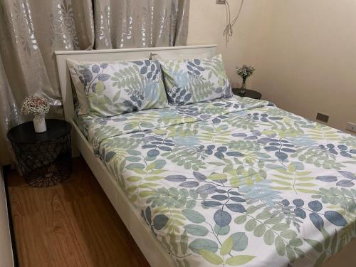 ein Bett mit Bettdecke und Kissen in einem Schlafzimmer in der Unterkunft Baylight Studio in Sampong