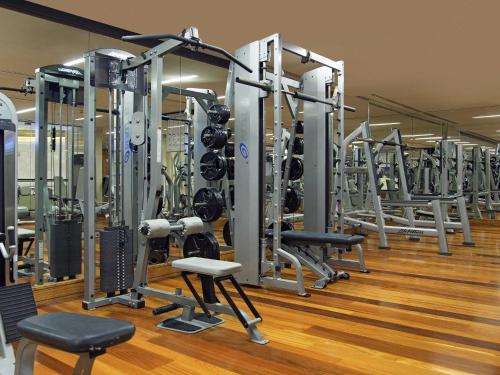 a gym with a row of tread machines at La Cigale Hotel Managed by Accor in Doha