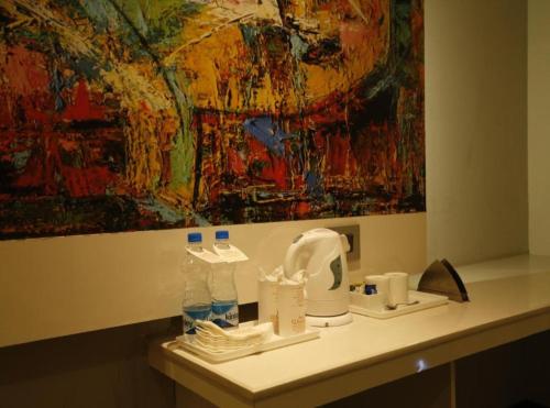 a bathroom counter with a painting on the wall at Hotel Olive Aero Suites Near Delhi IGI Airport in New Delhi
