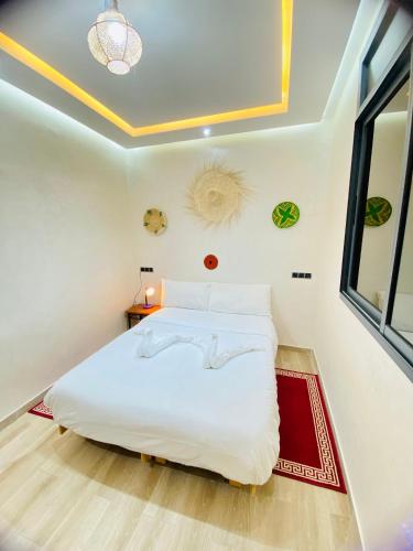 a bedroom with a white bed and a window at ocean view house in Imsouane