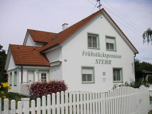 a white house with a white picket fence at Frühstückspension Sterr in Strebersdorf