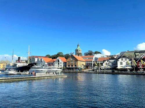 a harbor with a town and a boat in the water at Dali City Senter Ap 2 in Stavanger