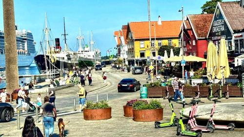 a group of people walking on a street near a harbor at Dali City Senter Ap 2 in Stavanger