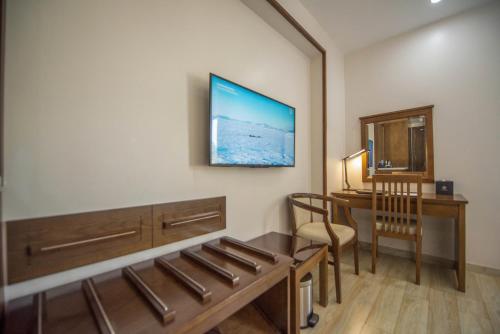a room with a desk and a table with a chair at Paradise Hotel - Pool , Sky Lounge , Gym - Massage & Wellness in Cat Ba