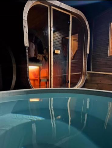a swimming pool with a reflection in the water at The Big Cwtch Shepherd's Hut in Kidwelly