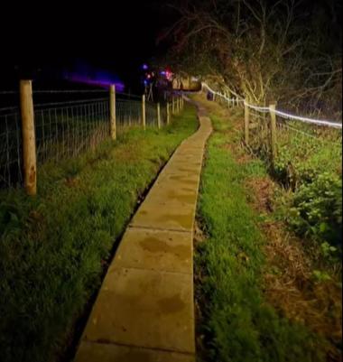 a concrete path in a field at night at The Big Cwtch Shepherd's Hut in Kidwelly