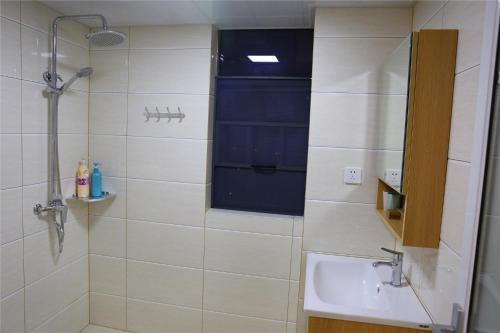 a bathroom with a shower and a sink and a window at Zhangjiajie 72 Wonder Tower Neighbour's House in Zhangjiajie